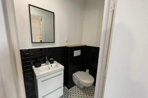 a bathroom with a white sink and a toilet at Black Serenity Suites Studio near Paris Orly in Thiais