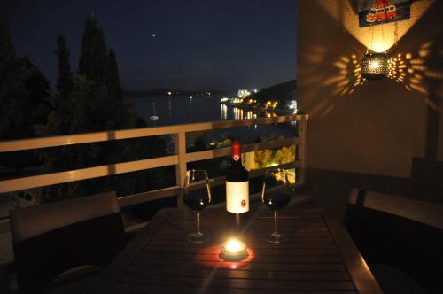 a table with two glasses of wine and a candle at Apartment Zara in Dubrovnik