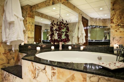 a bathroom with a tub and a large mirror at Hotel Doña Jimena in Villarcayo
