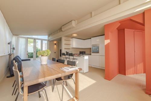 Home 12 في ميلانو: مطبخ وغرفة طعام مع طاولة وكراسي خشبية