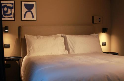 Home 12 في ميلانو: سرير بشرشف ووسائد بيضاء في غرفة النوم