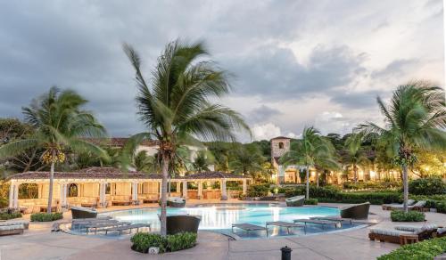 um resort com piscina e palmeiras em Rancho Santana em El Limón