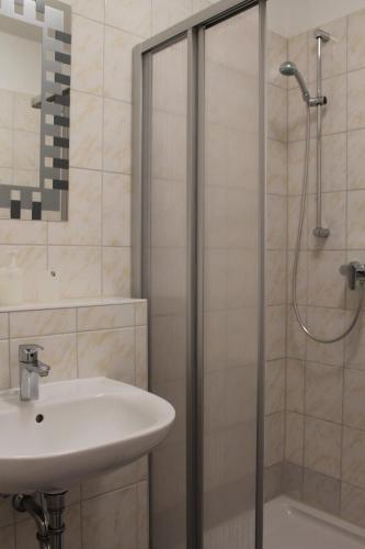 a bathroom with a sink and a shower at Hotel Pension Schwerin-Haus Schreiber in Schwerin