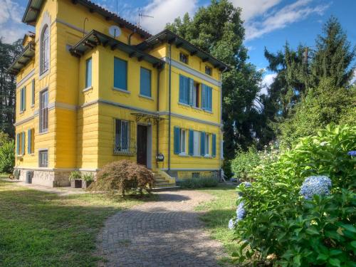 ストレーザにあるcasa Yin e Yangの庭の青窓のある黄色い家