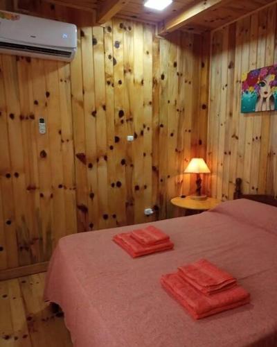 - une chambre avec un lit et 2 serviettes rouges dans l'établissement Departamento Luminoso, à Montecarlo