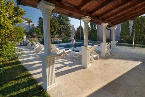 a group of chairs and a pavilion with a pool at Relax House Nizic in Dražice