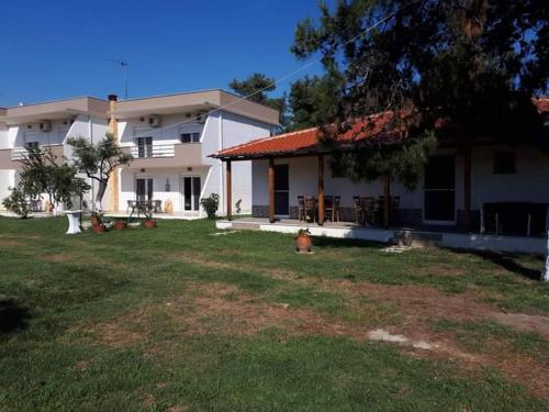 a house with a fire hydrant in front of a yard at Studios Dimitraki in Skala Rachoniou