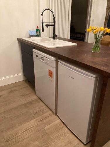 a kitchen with a sink and a dishwasher at Lime Tree Cottage in Tillingham