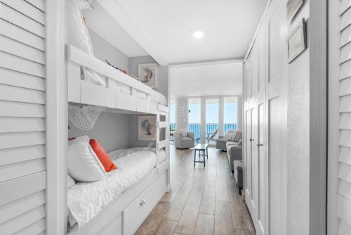 a bedroom with a bunk bed and a living room at Santa Rosa Dunes 1063 in Pensacola Beach