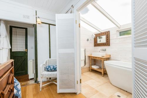 a bathroom with a tub and a toilet and a sink at The Folly in Dartmouth