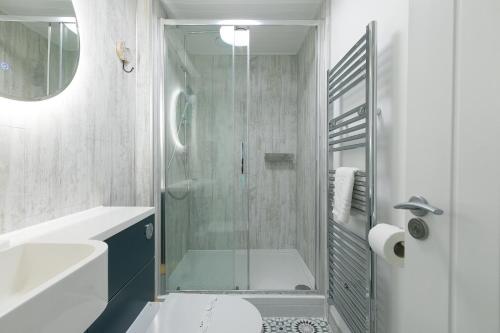 uma casa de banho com um chuveiro, um WC e um lavatório. em Flat 3, Pentowan Court em St. Ives
