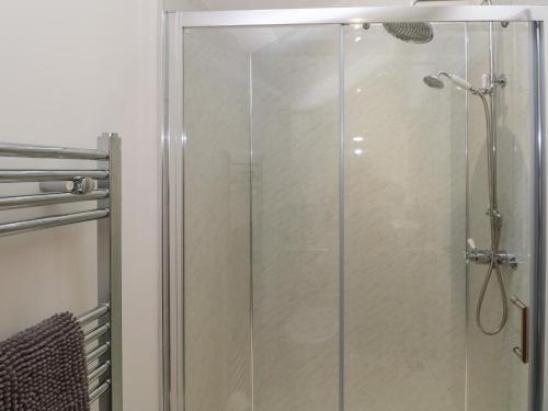een douche met een glazen deur in de badkamer bij The Cwtch in Bridgend
