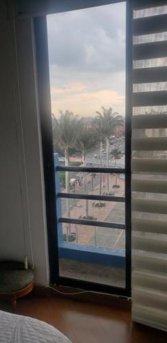Cette chambre dispose d'une fenêtre offrant une vue sur la rue. dans l'établissement APARTA-HOTEL BADEN, à Bogotá