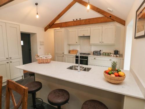 a kitchen with a counter with a bowl of fruit on it at The Byre in Bridgend