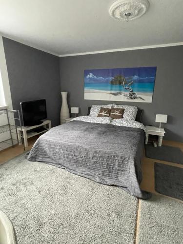 a bedroom with a bed with a painting on the wall at Appartment 53qm im Architektenhaus - 2 Schlafzimmer mit Küche und Bad, nur 2min von A8 - ruhig und modern in Irschenberg