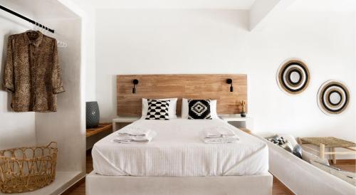 a bedroom with a bed with white sheets and pillows at Cactus Suites Kythnos in Mérikhas