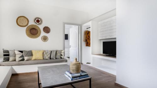 a living room with a couch and a tv at Cactus Suites Kythnos in Mérikhas