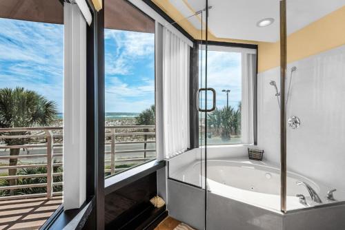 a bathroom with a tub and large windows at Palm Beach Club 3-235 in Pensacola Beach