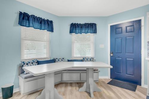 a dining room with a white table and blue doors at The Pal House in Navarre