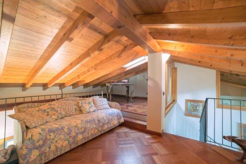 una sala de estar con sofá y techos de madera. en Villa Gaia, en Stresa