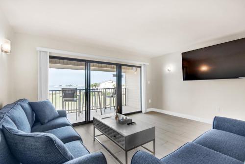 a living room with two blue chairs and a tv at Santa Rosa Dunes 425 in Pensacola Beach