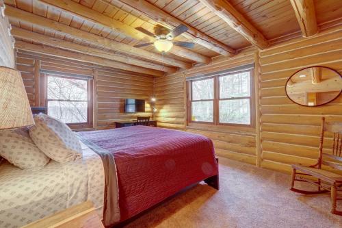 a bedroom with a bed in a log cabin at Interlochen Cabin with Fireplace - Near State Park! in Interlochen