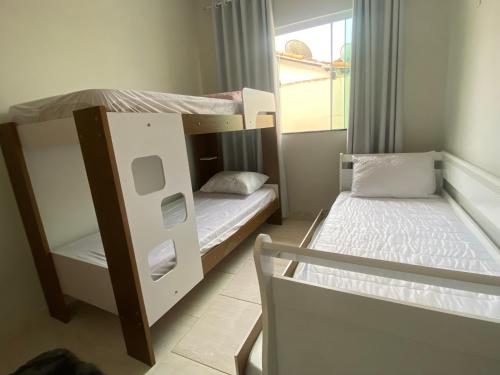 2 łóżka piętrowe w niewielkim pokoju z oknem w obiekcie Casa aconchegante para lazer e descanso Araruama w mieście Araruama