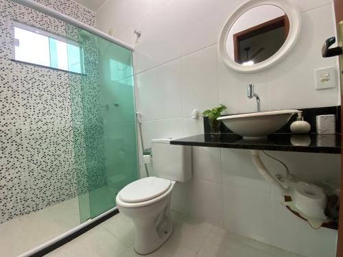 a bathroom with a toilet and a sink and a mirror at Casa aconchegante para lazer e descanso Araruama in Araruama