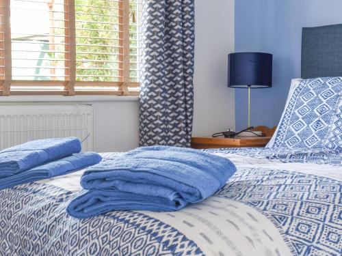 um quarto com uma cama com toalhas azuis em Cranleigh em Pakefield