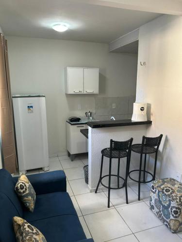 Il comprend un salon avec un canapé bleu et une cuisine. dans l'établissement Apartamento Premium Grand Luxo, à Fortaleza