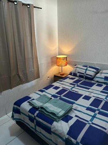 Un dormitorio con una cama azul y blanca con una lámpara en Apartamento Premium Grand Luxo, en Fortaleza