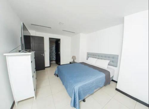 een slaapkamer met een bed en een flatscreen-tv bij Bellini luxury - Puerto Santa Ana in Guayaquil