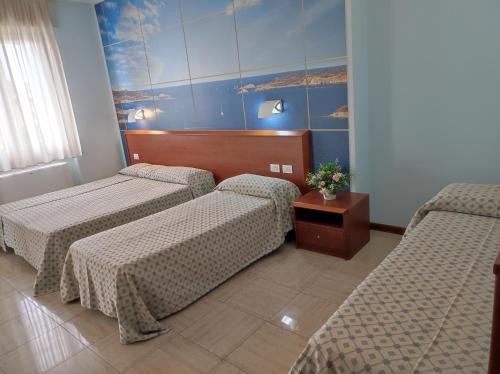 ブレシアにあるHotel Industriaのベッド2台とテーブルが備わるホテルルームです。