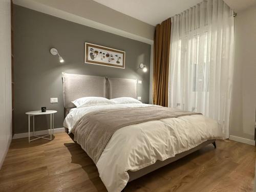 - une chambre avec un grand lit et une fenêtre dans l'établissement Apartment in Tirana, à Tirana