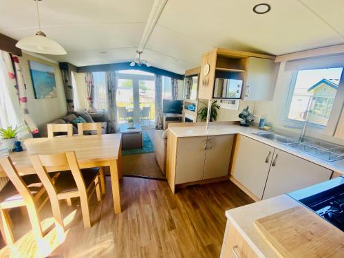 a kitchen and living room with a table and a dining room at B47 Caravan Seven Bays in Padstow