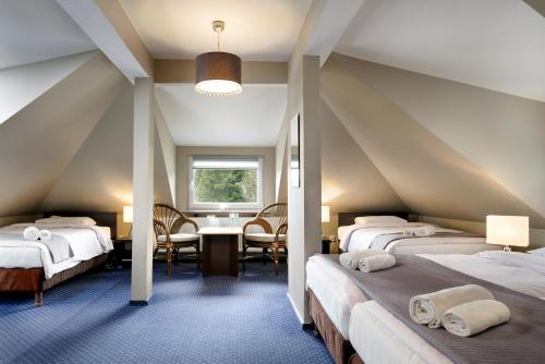 クリニツァ・ズドルイにあるPensjonat Orleの屋根裏部屋(ベッド3台、テーブル、椅子付)