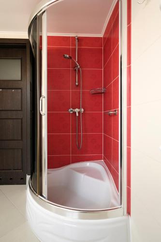 a bathroom with a shower with red tiles at Pensjonat Orle in Krynica Zdrój