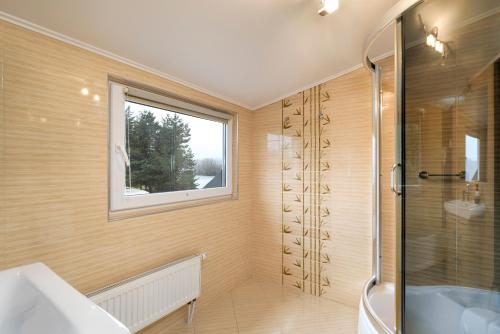 a bathroom with a shower and a sink and a window at Pensjonat Orle in Krynica Zdrój