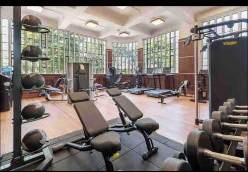 a gym with lots of treadmills and weights at Art deco lodging in London in Hayes