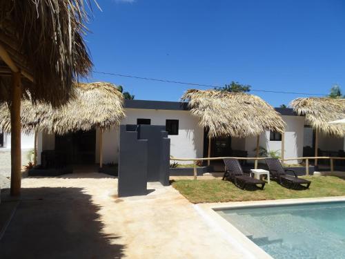 a villa with a swimming pool and two chairs and a house at BUNGALOWS COLIBRI in Las Galeras