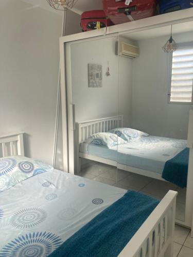 um quarto com duas camas e um espelho em Martinique trois ilets face à la mer em Les Trois-Îlets