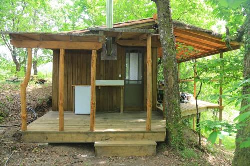 drewniany domek w lesie z drzewem w obiekcie Cabane au cœur de la forêt des Landes de Gascogne w mieście Belin-Beliet