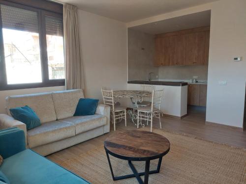 ein Wohnzimmer mit einem Sofa und einem Tisch sowie eine Küche in der Unterkunft El Balcón de la Vega in Pareja