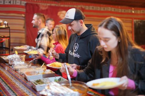 eine Gruppe von Menschen, die Essen am Buffet bekommen in der Unterkunft Quite bedouin life in Wadi Rum