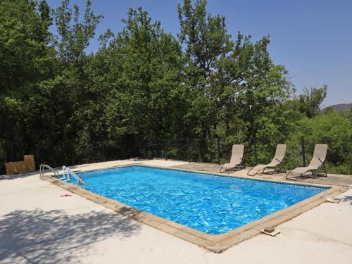 a large swimming pool with two chairs at Gîte Nature et Calme du Travers in Valaurie