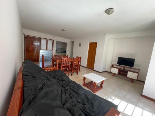 a living room with a couch and a television and a table at Casa Storni in Mar del Plata