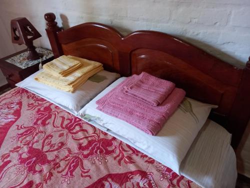 1 cama con sábanas rojas y blancas y mantas rosas en CASA PARA ALQUILER LA LILI en Uspallata