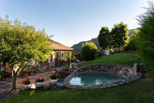 un patio trasero con una piscina de piedra en el césped en Loft de montaña en Buiza