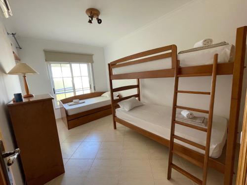 a room with two bunk beds and a ladder at A Casa do Carlos in Vila Nova de Cacela