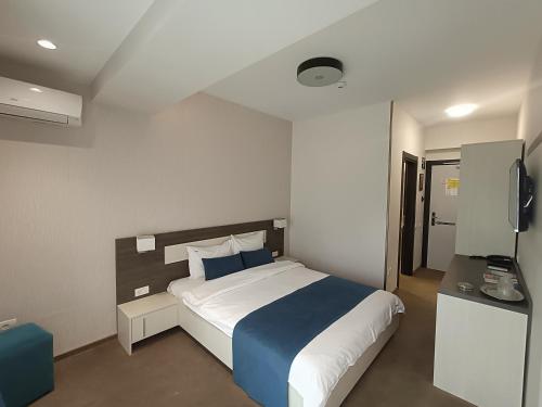 - une chambre avec un grand lit et une télévision dans l'établissement Aparthotel Mamaia, à Mamaia